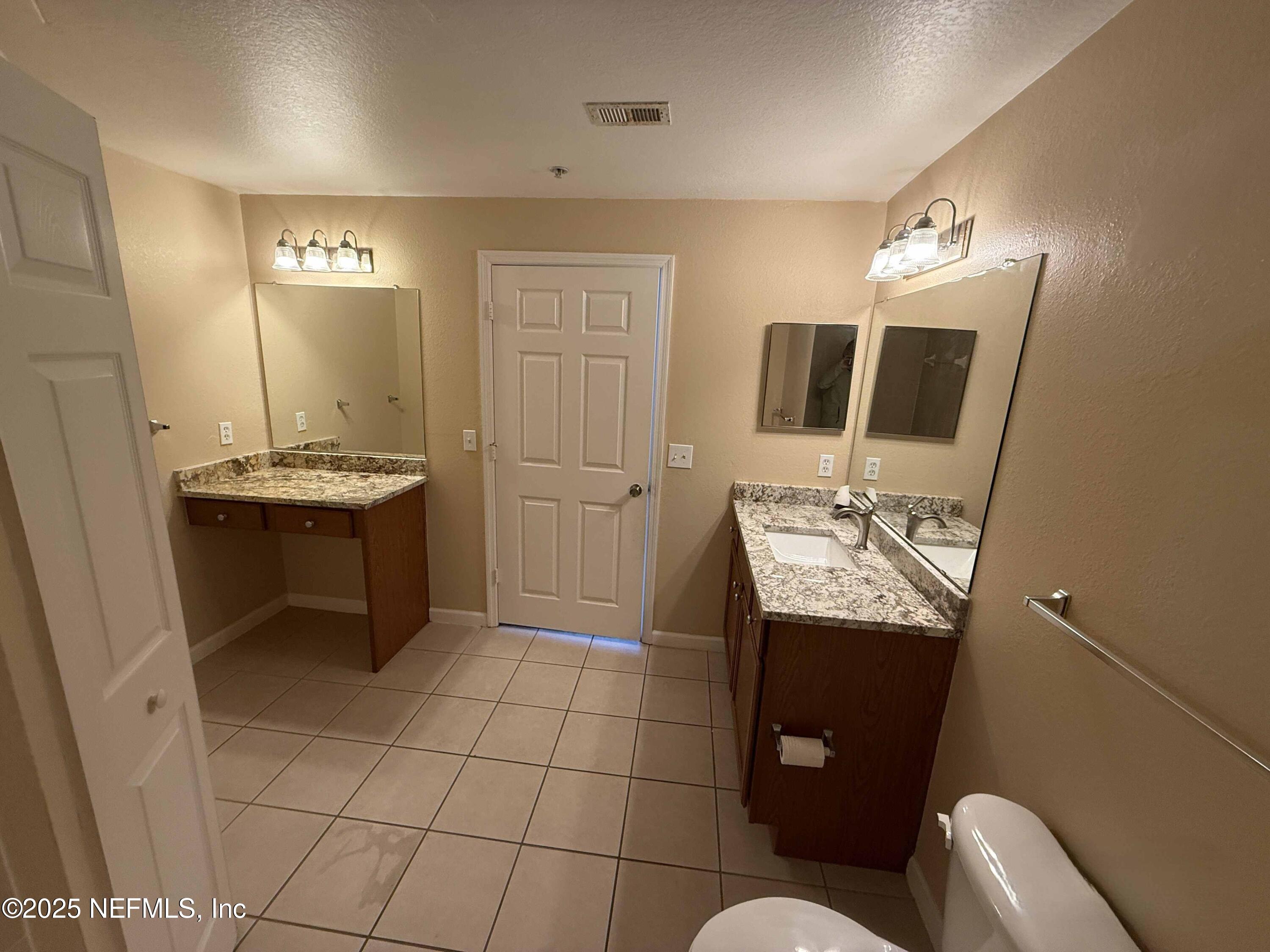 8550 Touchton Road, Unit 1633 Jacksonville, FL 32216 - Photo 19 of 21 a bathroom with a sink toilet and mirror