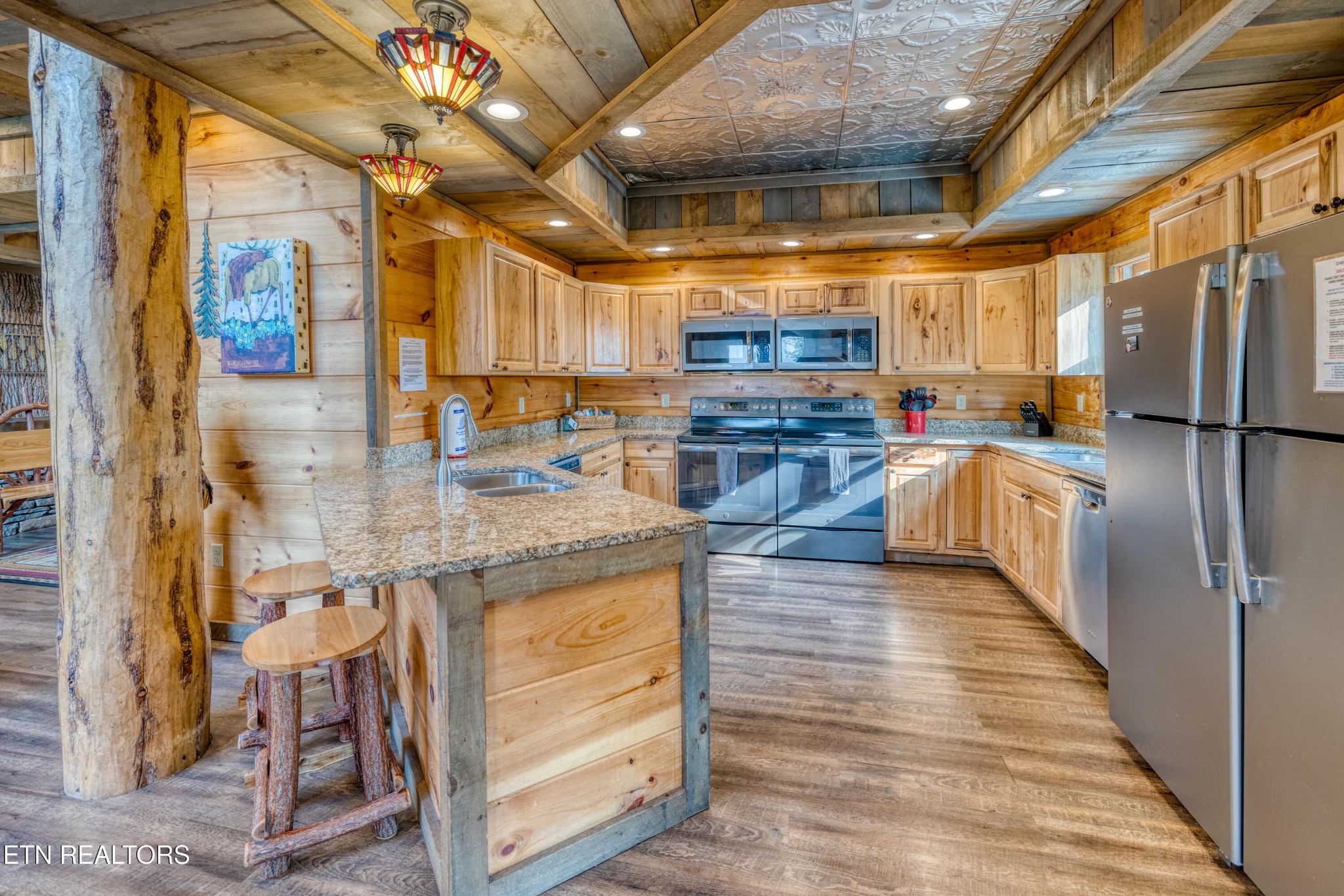 809 Pinecrest Way Sevierville, TN 37862 - Photo 9 of 60 a kitchen with stainless steel appliances granite countertop a refrigerator a sink dishwasher a stove and a dining table with wooden floor
