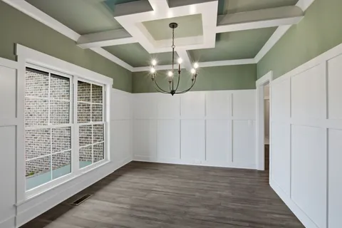 a view of a livingroom with wooden floor a ceiling fan and window