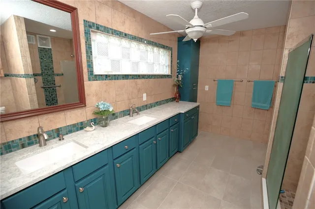 a bathroom with a granite countertop sink a large mirror and a shower