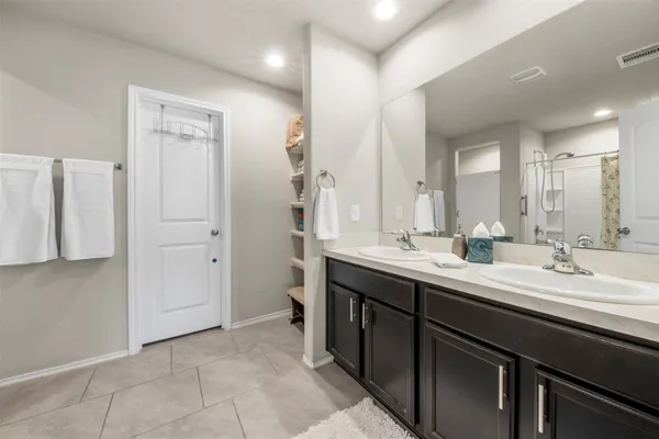 a bathroom with a double vanity sink a mirror and a shower