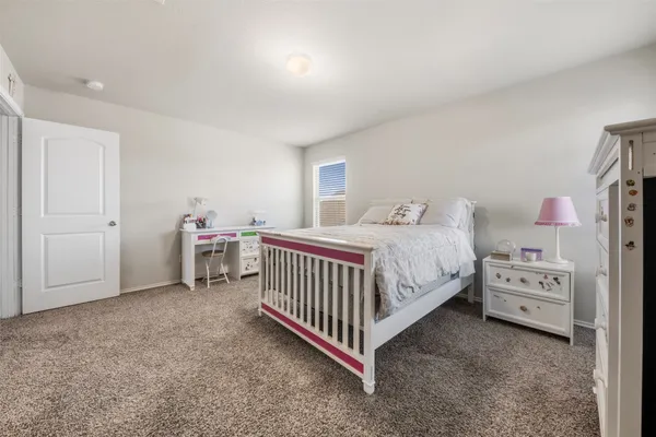 a bedroom with a bed and a baby crib
