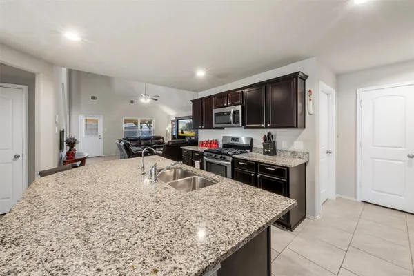 a kitchen with stainless steel appliances granite countertop a sink refrigerator and cabinets