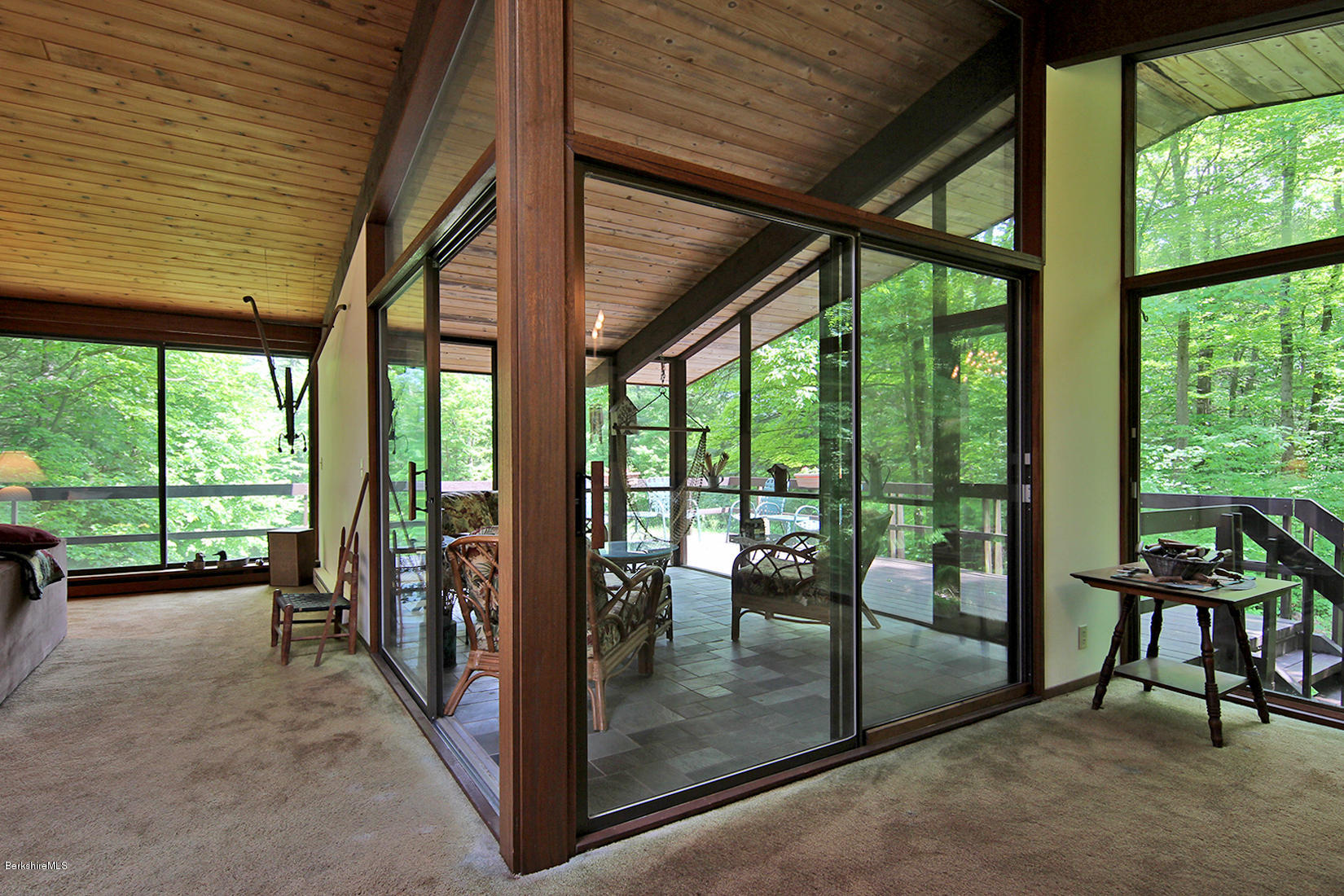 63 Monterey Road Tyringham, MA 01264 - Photo 7 of 34 a view of a porch with chairs and floor to ceiling window