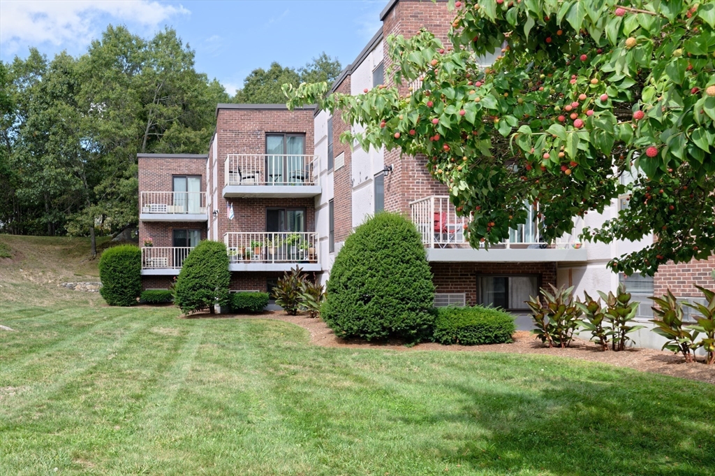 147 Turner Road, Unit 98 Holliston, MA 01746 - Photo 12 of 42 a front view of a house with a yard and garage