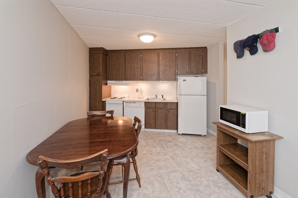 147 Turner Road, Unit 98 Holliston, MA 01746 - Photo 21 of 42 a kitchen with a table chairs and a refrigerator