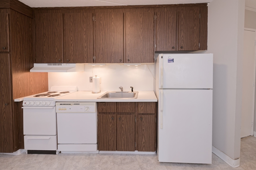 147 Turner Road, Unit 98 Holliston, MA 01746 - Photo 23 of 42 a kitchen with a sink a refrigerator and cabinets