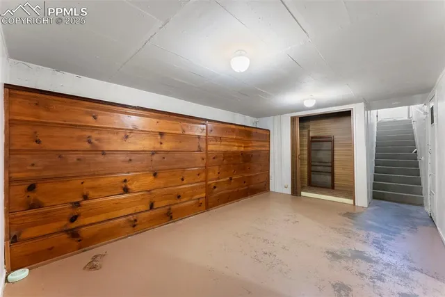 a view of an empty room with closet and cabinet