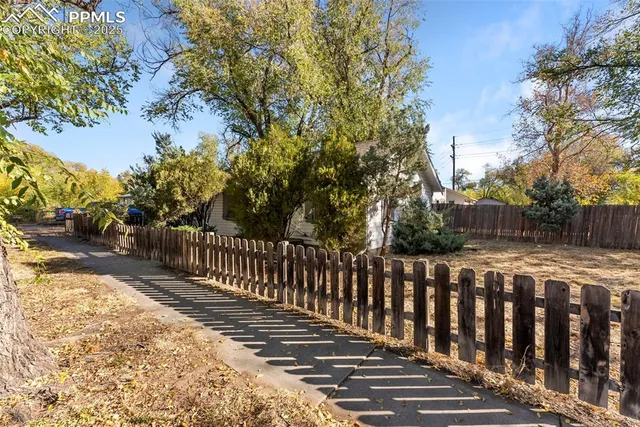 a view of a house with a yard and large tree