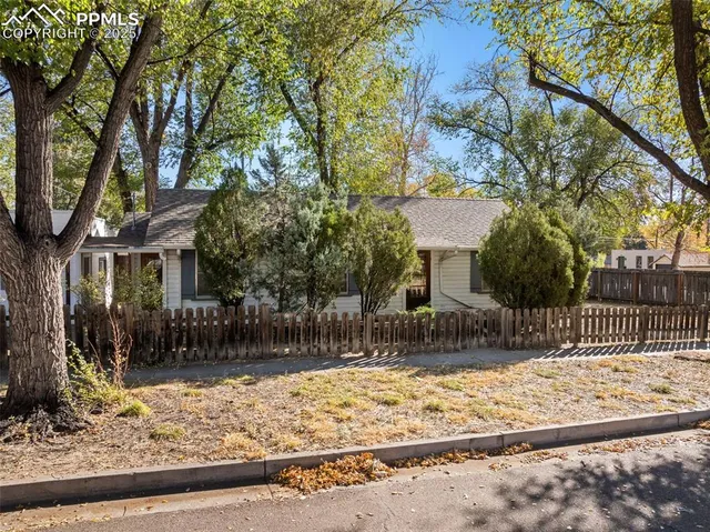 a front view of a house with a yard and trees