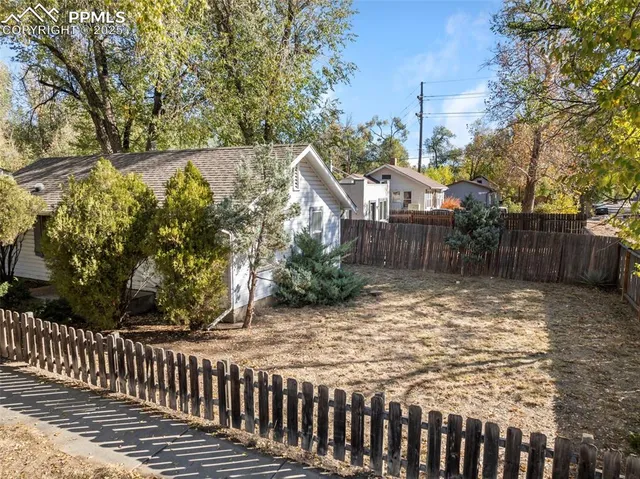 a view of a house with a large trees and plants