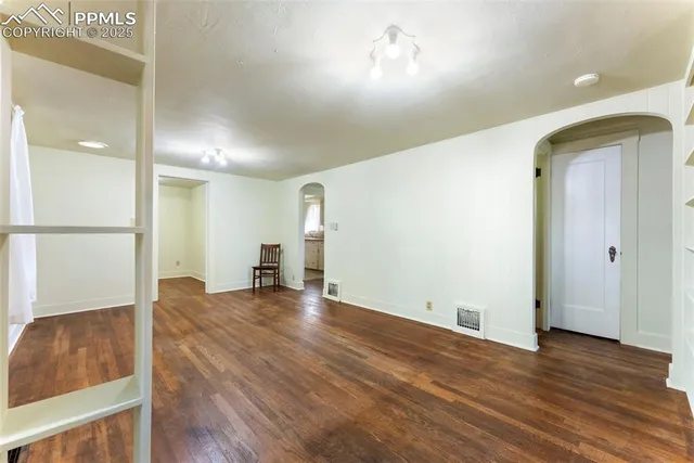 a view of empty room with wooden floor