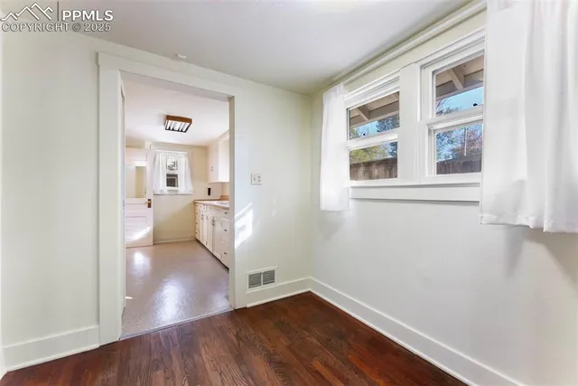 a view of a kitchen with wooden floor and a window