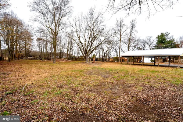 a front view of house with yard and trees around