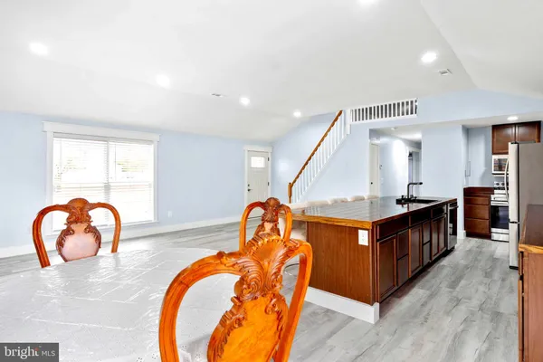 a kitchen with stainless steel appliances granite countertop a kitchen island a stove and a sink