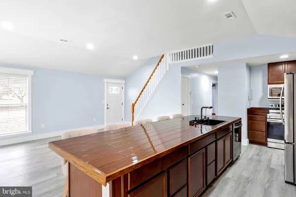 a kitchen with stainless steel appliances granite countertop a stove and a view of dining room