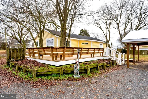 a view of a house with large trees in a backyard
