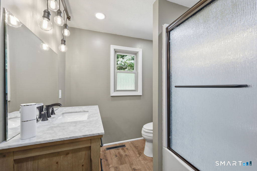 630 South Elm Street Wallingford, CT 06492 - Photo 15 of 30 a bathroom with a sink a toilet and mirror
