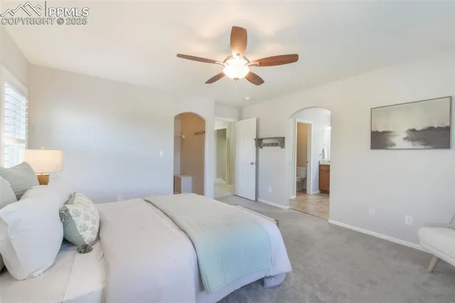a spacious bedroom with a bed and a chandelier