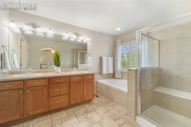 a spacious bathroom with a tub sink shower and mirror