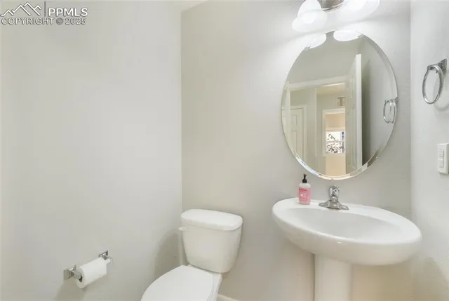 a bathroom with a toilet a sink and mirror