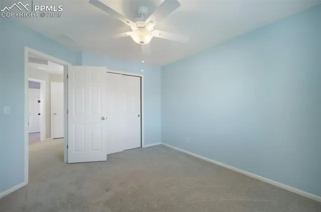 an empty room with a chandelier fan and a ceiling fan