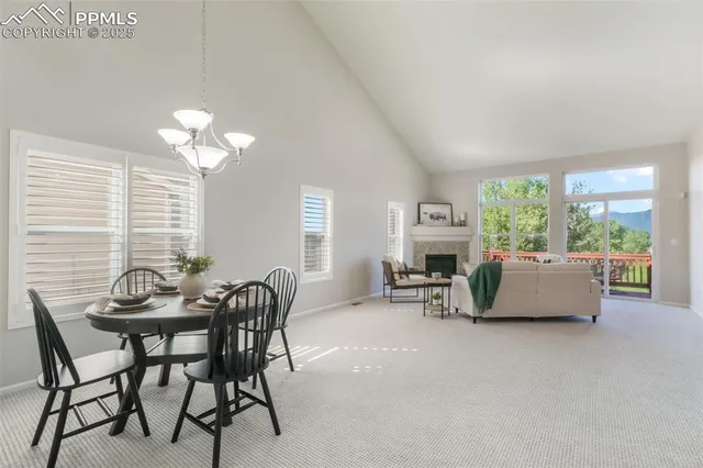 a dining room with furniture a fireplace and large windows