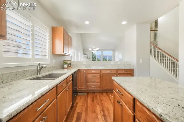a kitchen with granite countertop a sink a counter space and cabinets