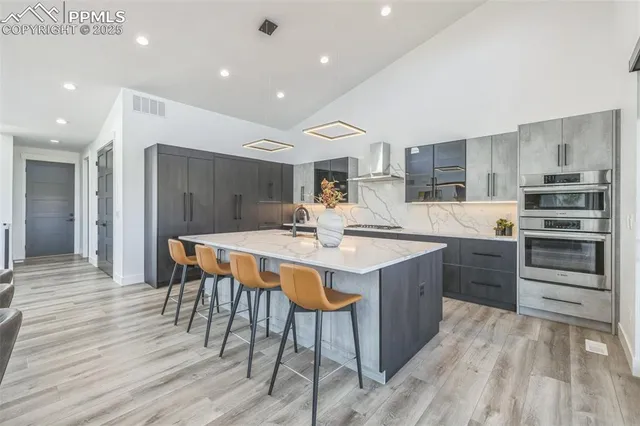 a kitchen with a table chairs sink and cabinets