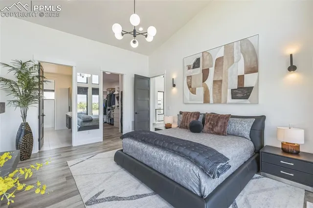 a bedroom with a large bed a chandelier and closet
