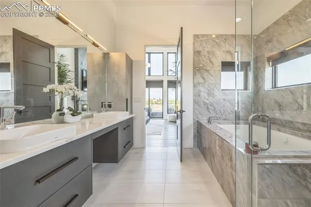 a large bathroom with a double vanity sink a large mirror and a bathtub
