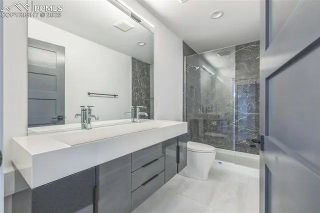 a bathroom with a double vanity sink toilet and shower