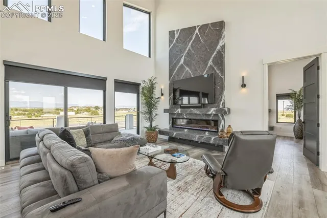 a living room with furniture a fireplace and a floor to ceiling window