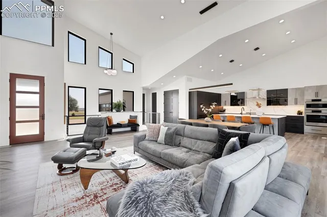 a living room with furniture kitchen view and a window