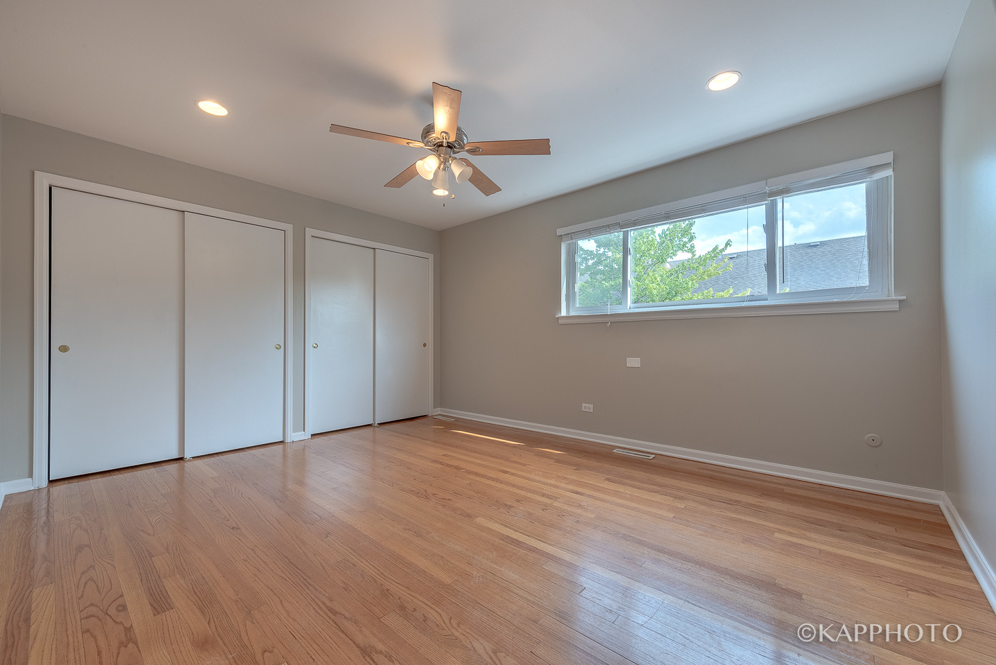 1406 Shermer Road, Unit 1406 Northbrook, IL 60062 - Photo 15 of 28 an empty room with wooden floor chandelier fan and windows