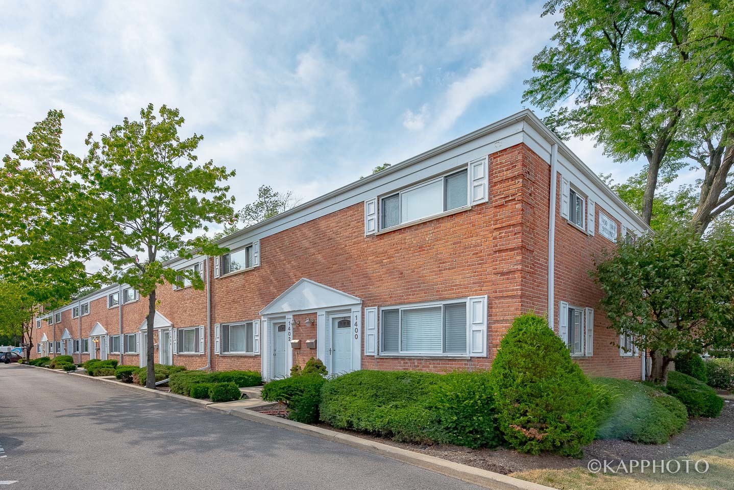 1406 Shermer Road, Unit 1406 Northbrook, IL 60062 - Photo 2 of 28 a front view of a house with a yard and garage