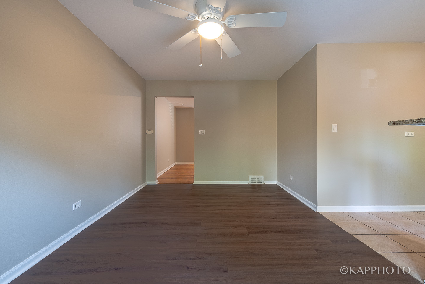 1406 Shermer Road, Unit 1406 Northbrook, IL 60062 - Photo 8 of 28 an empty room with wooden floor chandelier fan and windows