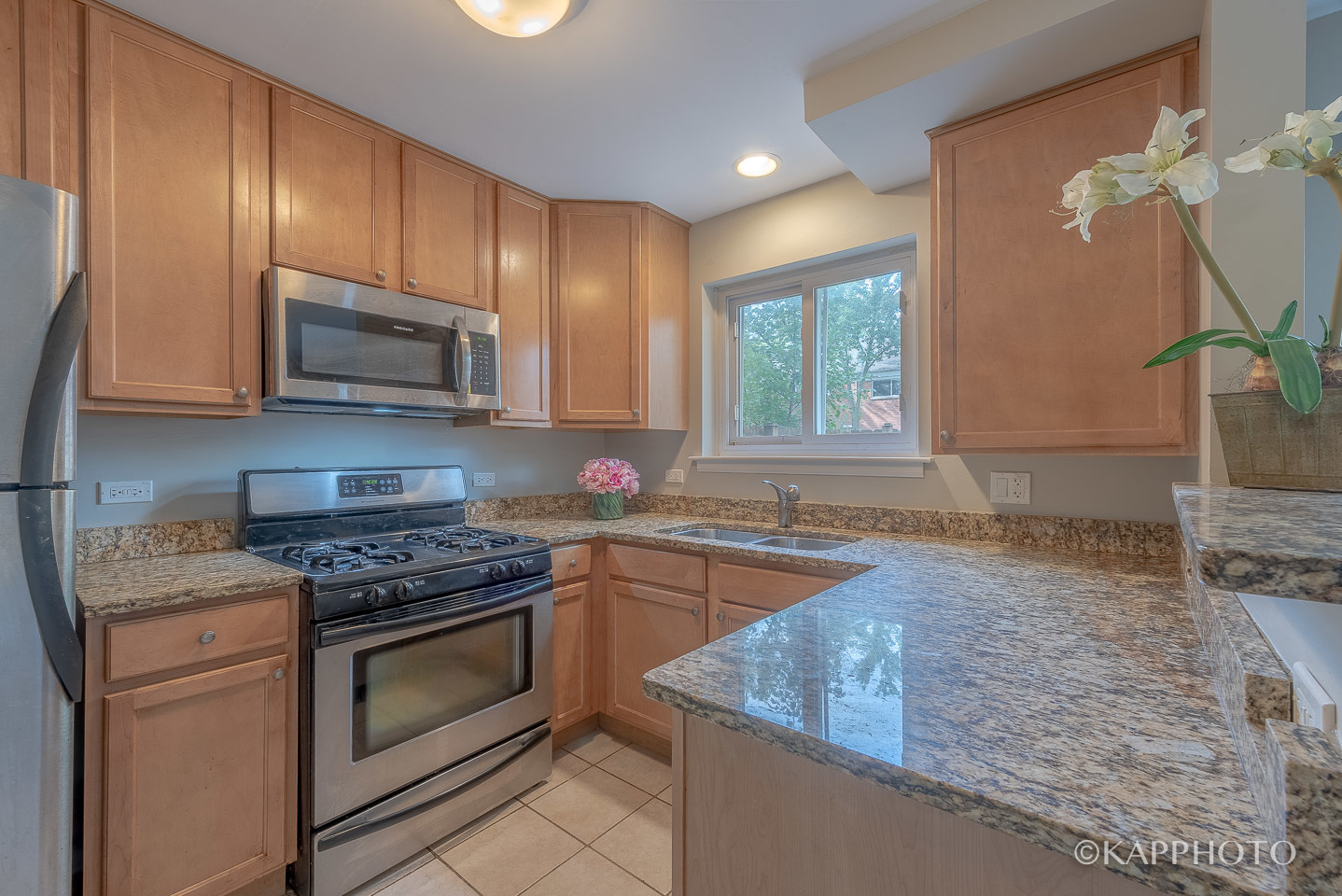 1406 Shermer Road, Unit 1406 Northbrook, IL 60062 - Photo 10 of 28 a kitchen with granite countertop a stove top oven microwave and cabinets