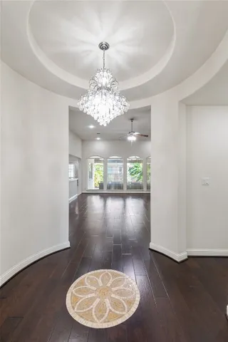 a view of a hallway with wooden floor and a bathroom
