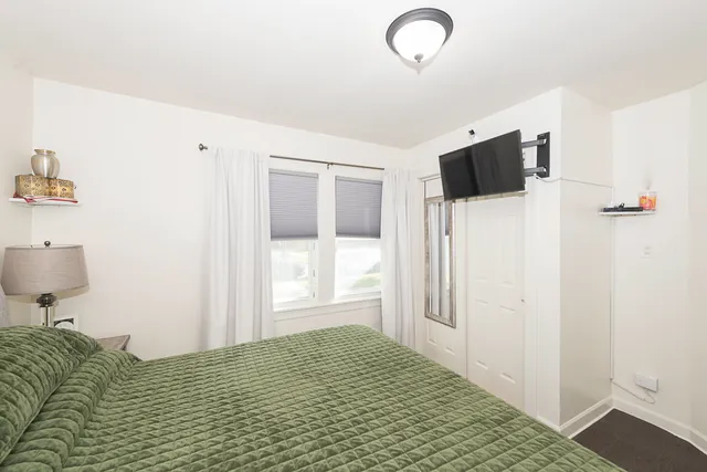 a bedroom with a bed and a flat tv screen