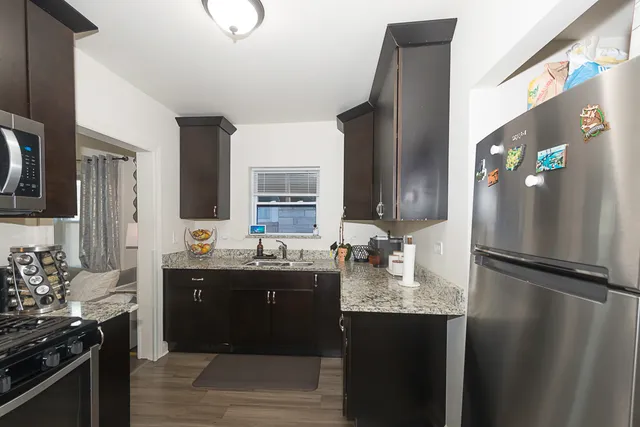 a kitchen with stainless steel appliances granite countertop a refrigerator and a sink