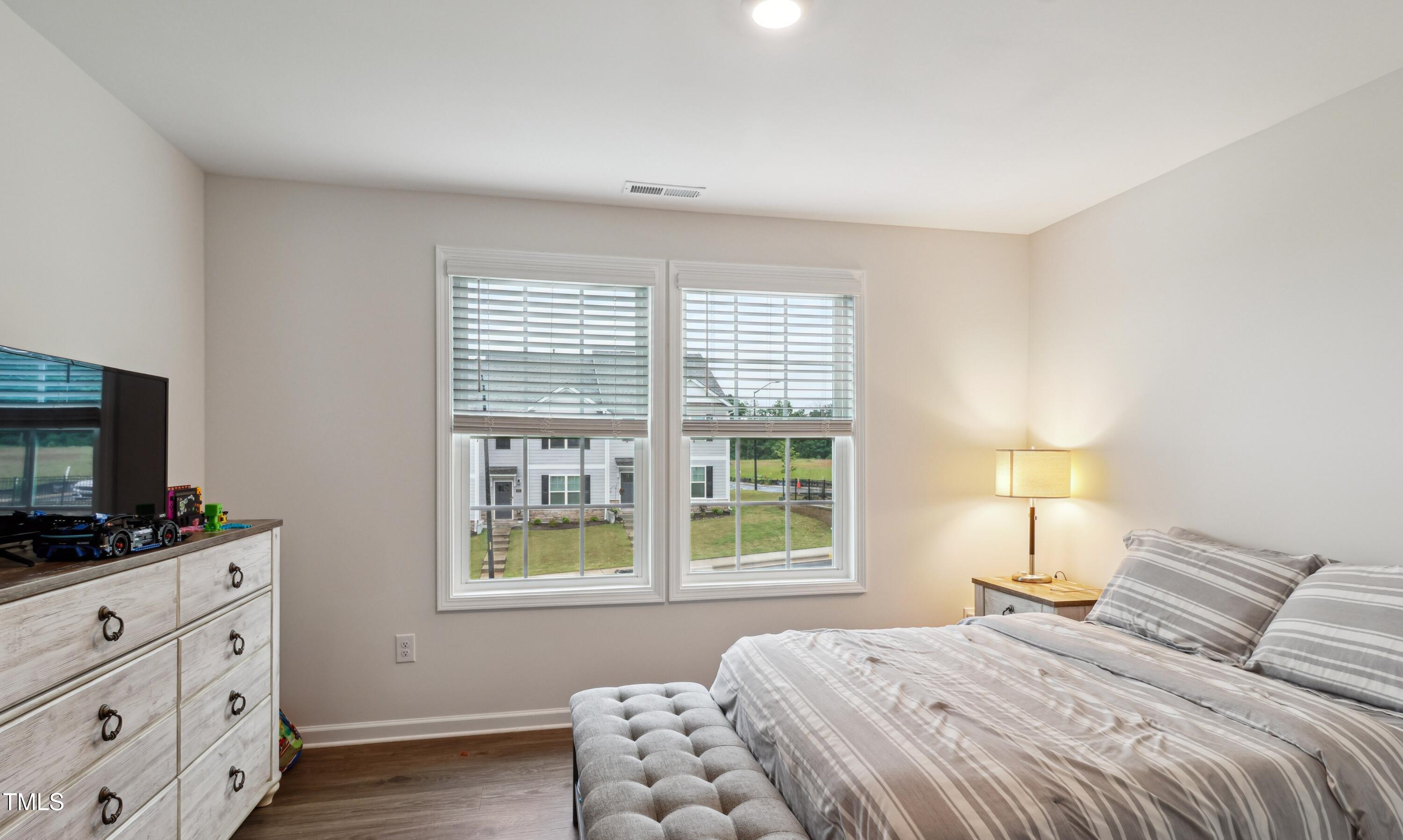 817 James J Freeland Memorial Drive Hillsborough, NC 27278 - Photo 19 of 33 a bedroom with a bed and a flat tv screen on a dresser