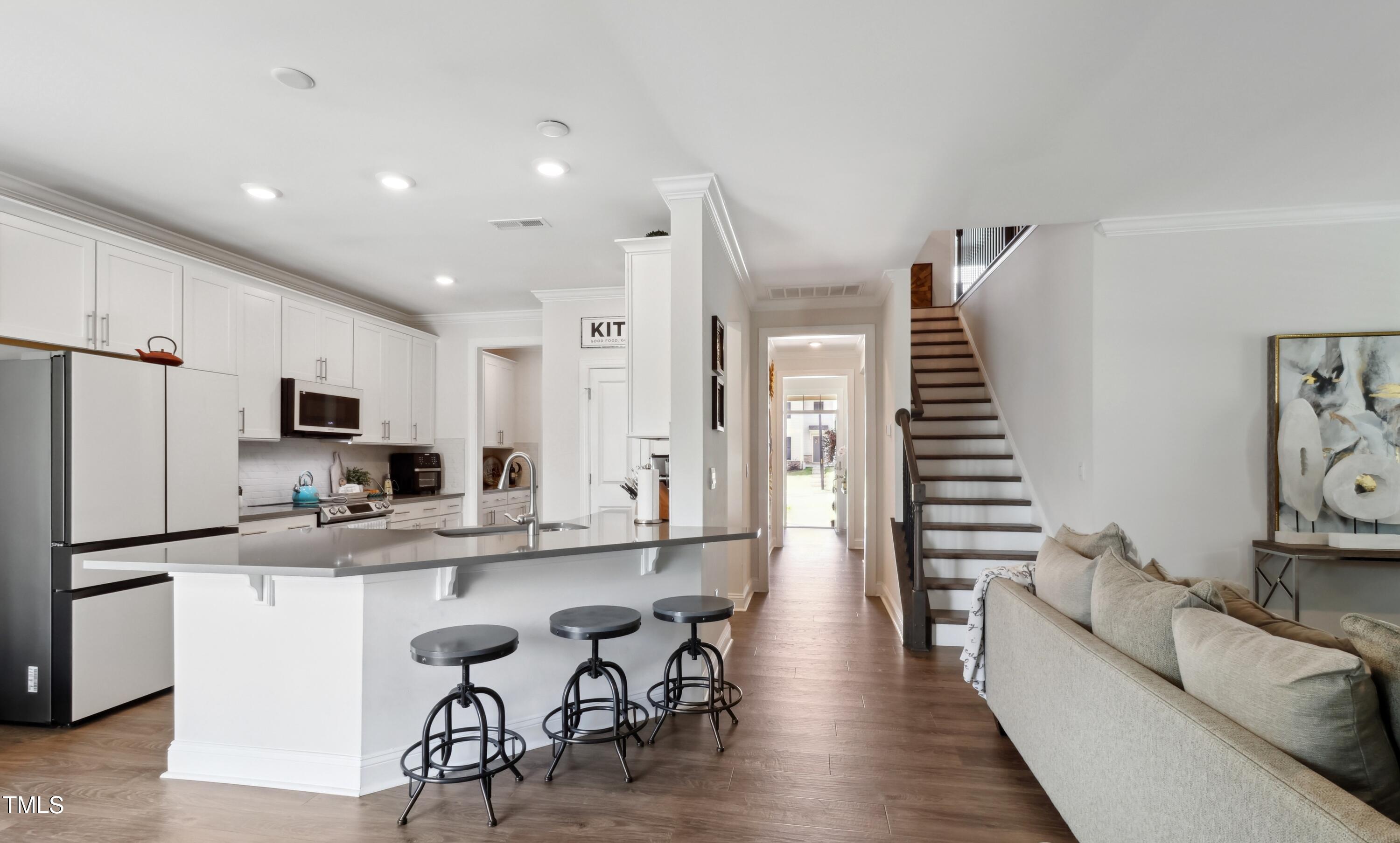 817 James J Freeland Memorial Drive Hillsborough, NC 27278 - Photo 6 of 33 a kitchen with stainless steel appliances kitchen island granite countertop a refrigerator a stove a sink and white cabinets with wooden floor