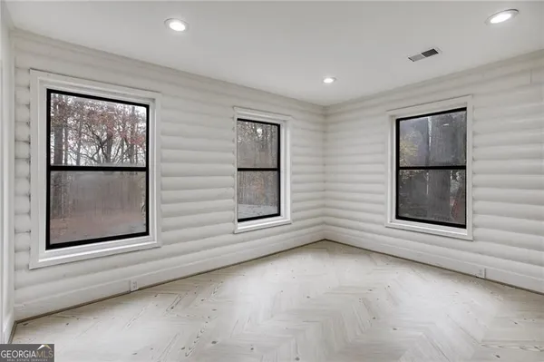 a view of an empty room with window and cabinet