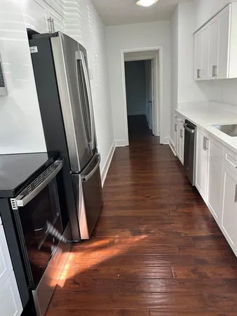 a view of a kitchen with wooden floor and staircase