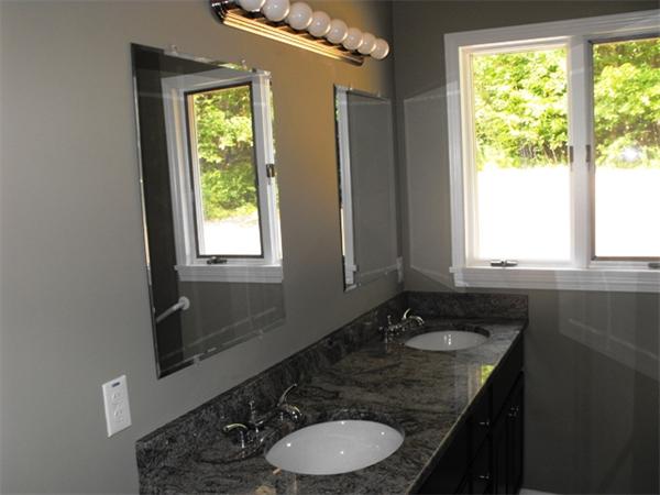 80 Woodman Road South Hampton, NH 03827 - Photo 10 of 14 a bathroom with a granite countertop sink a large mirror a window and a toilet