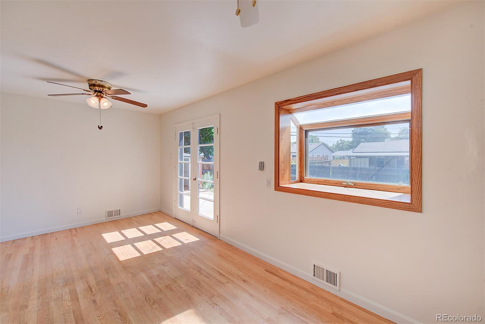 6054 Iris Way Arvada, CO 80004 - Photo 11 of 44 wooden floor in an empty room with a window