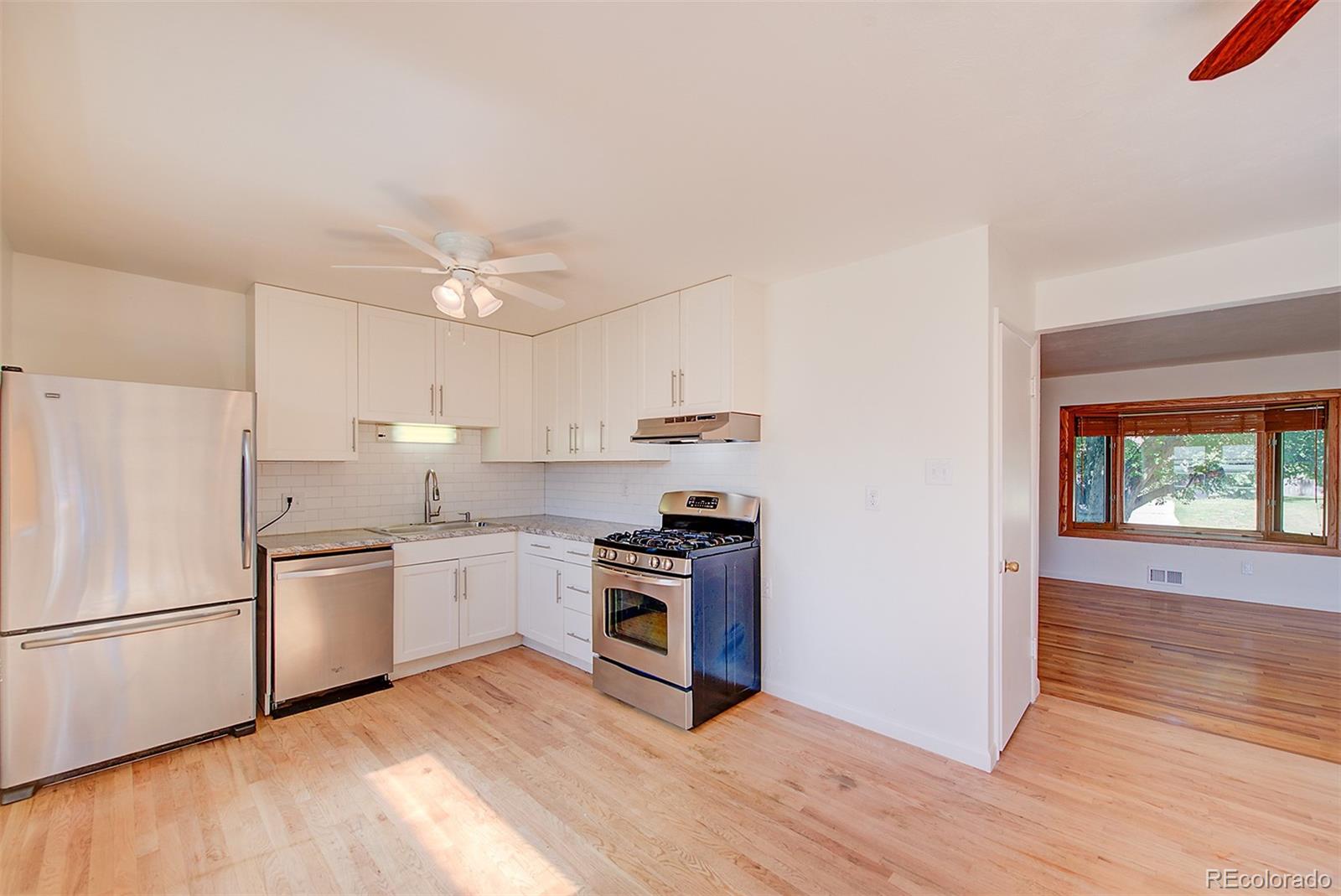 6054 Iris Way Arvada, CO 80004 - Photo 12 of 44 a kitchen with a stove a refrigerator and a stove top oven