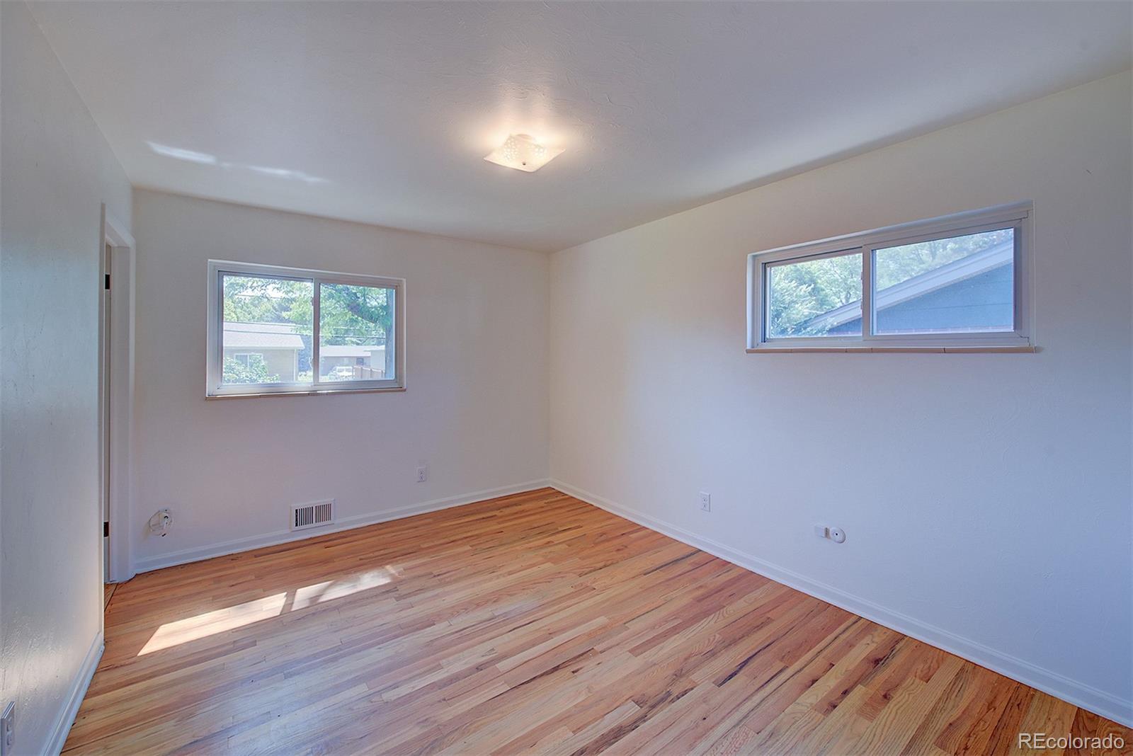 6054 Iris Way Arvada, CO 80004 - Photo 16 of 44 a view of empty room with wooden floor and fan