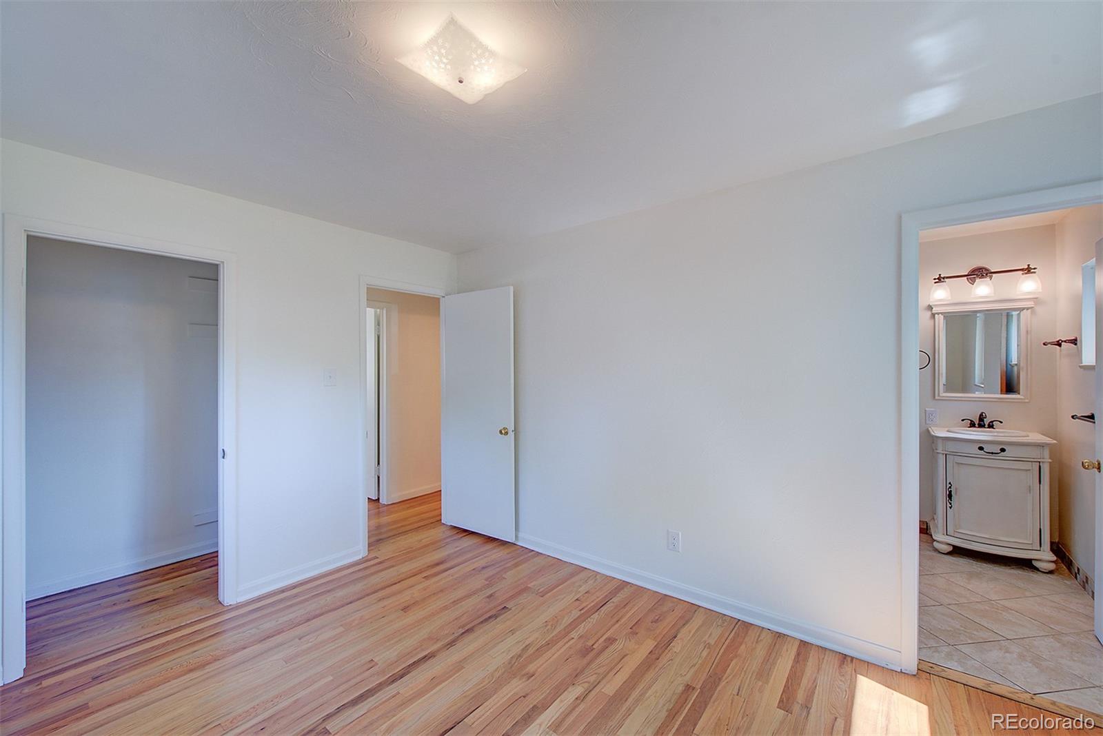 6054 Iris Way Arvada, CO 80004 - Photo 17 of 44 a view of an empty room with wooden floor and a window